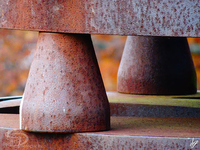 Detail view of rusty red metal plinths. The title of the picture is called - Friends.